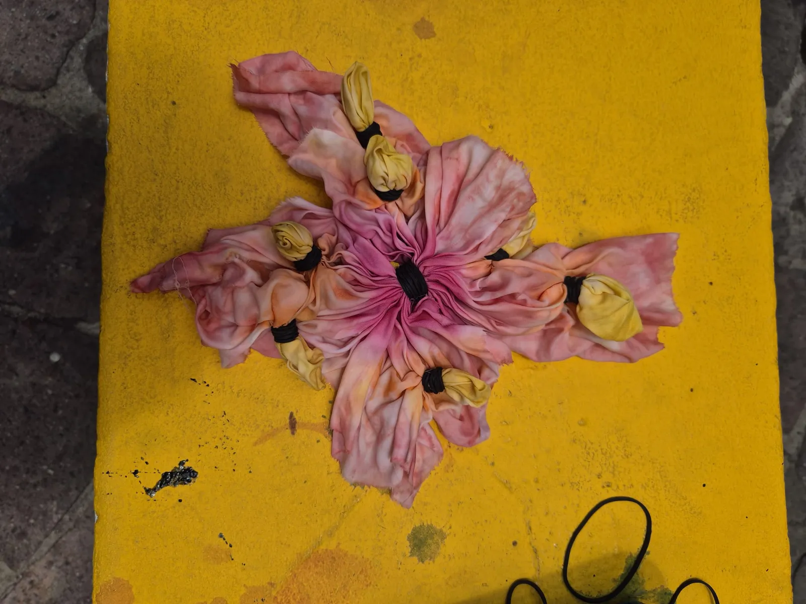 A folded and bound piece of fabric before dyeing, tied for an Adire pattern